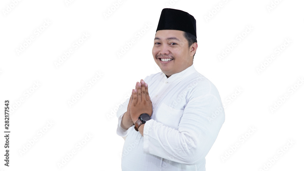 Portrait of overweight muslim man with head cap or songkok greeting at camera