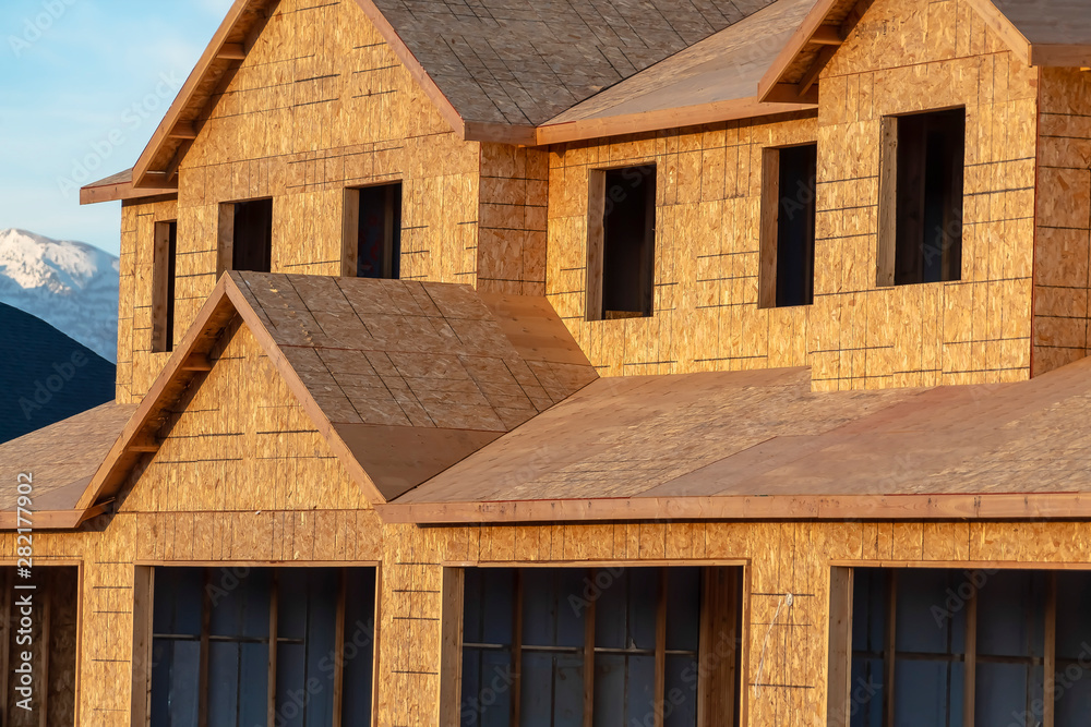 Close up of a new house exterior with unfinished wall roof and windows Close up of a new house exterior with unfinished wall roof and windows