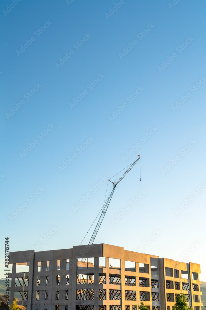 Framework of an unfinished building supported by metal rods against blue sky Framework of an unfinished building supported by metal rods against blue sky