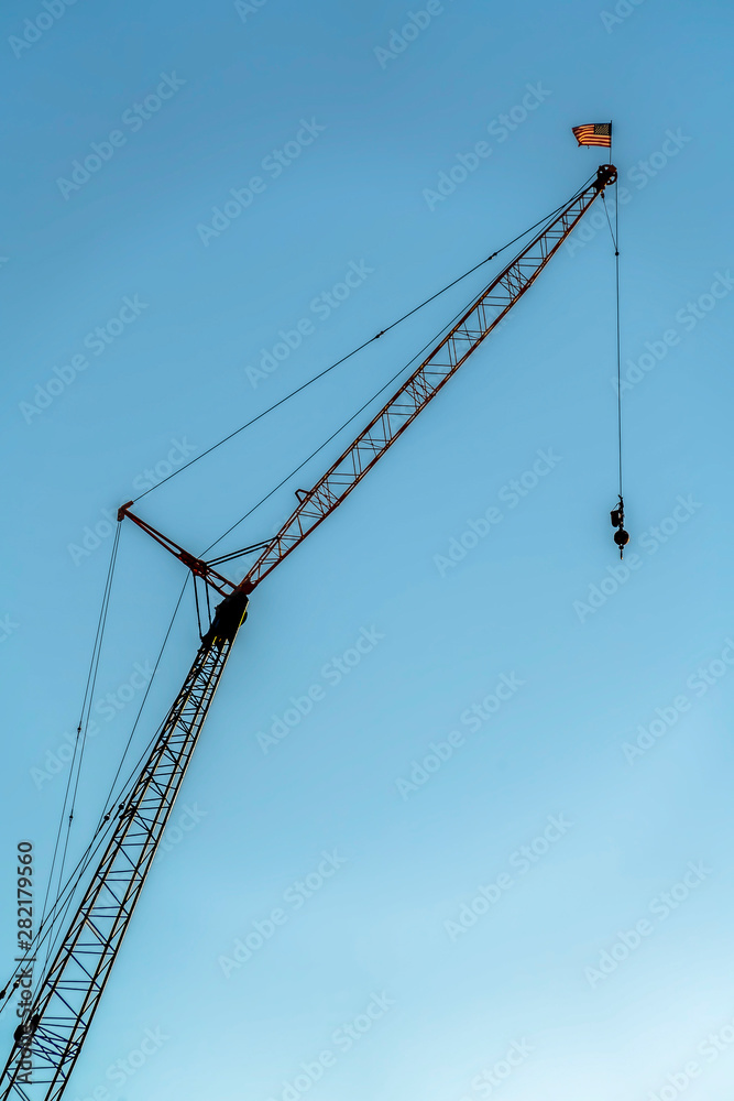 Construction crane viewed from below with blue sky background on a sunny day
