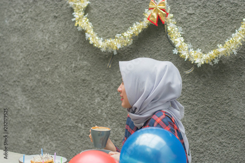 Photography attractive Hijab woman drinking cup of a coffee fat birthday surprise party