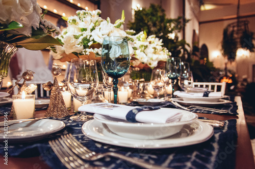 Wedding decorations. Table with white plate, cutlery, glasses and flowers.