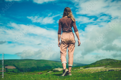 Young woman walking in wilderness on sunny sunmer day photo