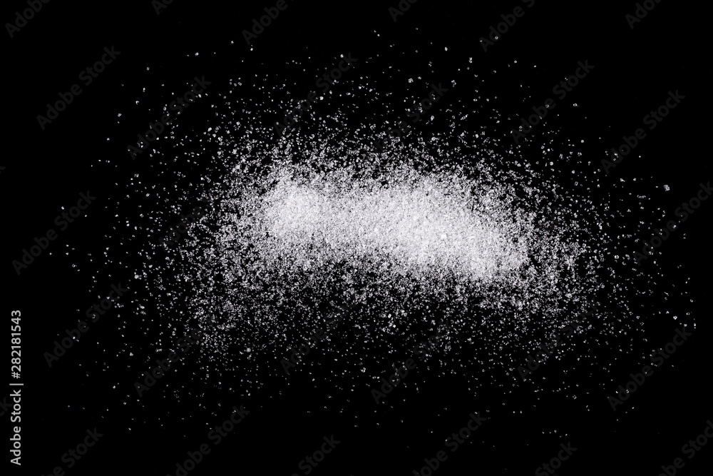 А pile of sugar on black background, top view.