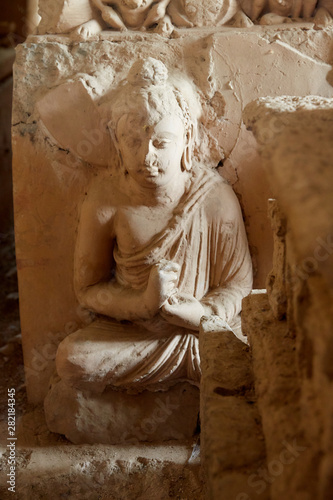 The sedentary statue of Buddha at the stupa base, Jaulian archaeological Complex, in the Khyber Pakhtunkhwa Province of Northern Pakistan photo