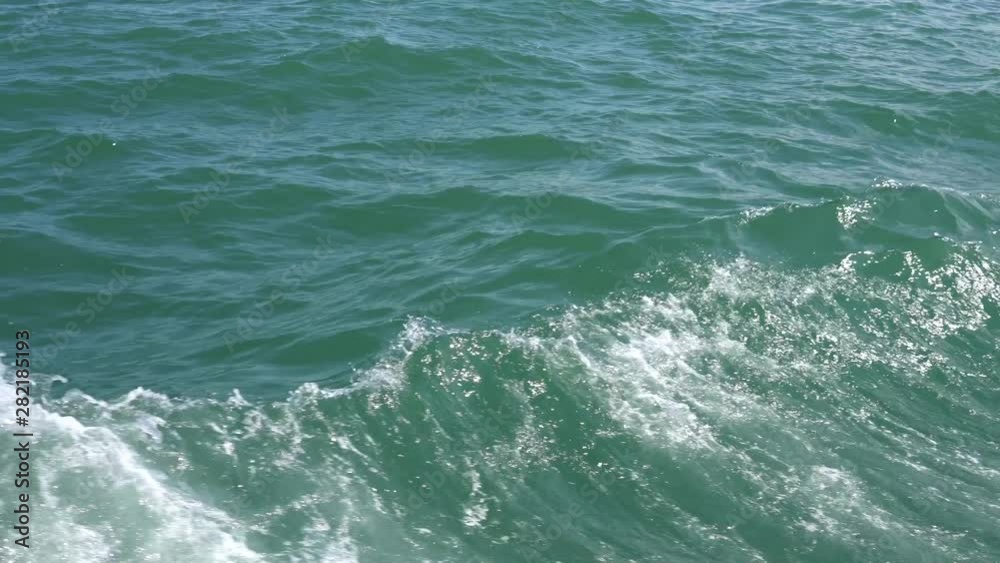 Ship wake on the ocean. Water foam trace behind the large ship goes till Ship wake on the ocean. Water foam trace behind the large ship goes till