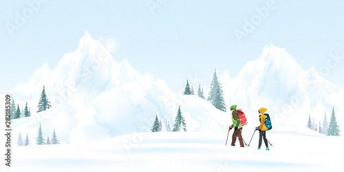 Mountain couple climbers with backpacks walking through heavy snow in winter season.