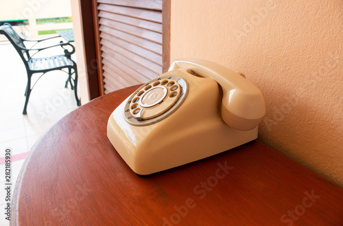 A retro telephone on wood table. Side of the classic phone.