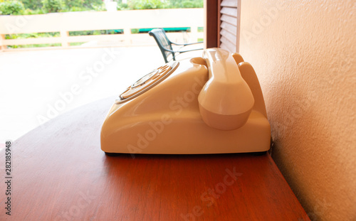 A retro telephone on wood table. Side of the classic phone.