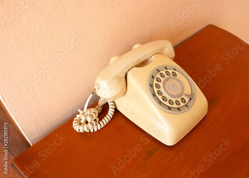 A retro telephone on wood table. Side of the classic phone.