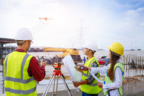 Drone operated by construction worker on building site,flying with drone.