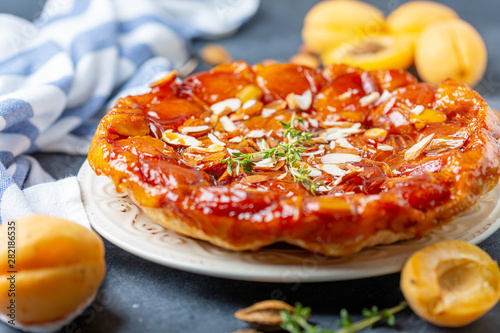 Apricot and almond tarte tatin on a white plate.