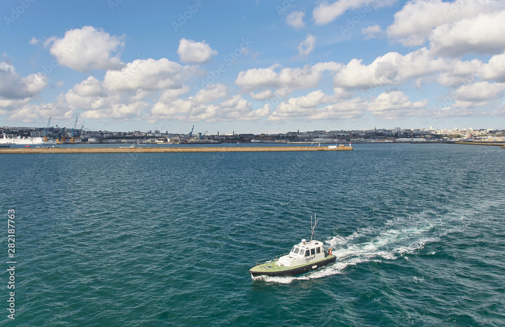Naklejka premium The French Pilot Boat escorting a Vessel out of Brest Harbour, and into Open seas on a fine Spring Day.