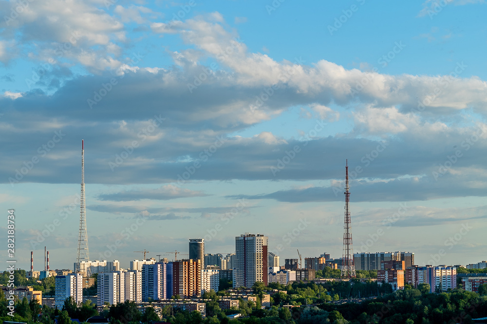 View of one of the beautiful places of Perm – the area of the district City hills on a summer evening. Trees, high-rise buildings, television towers.
