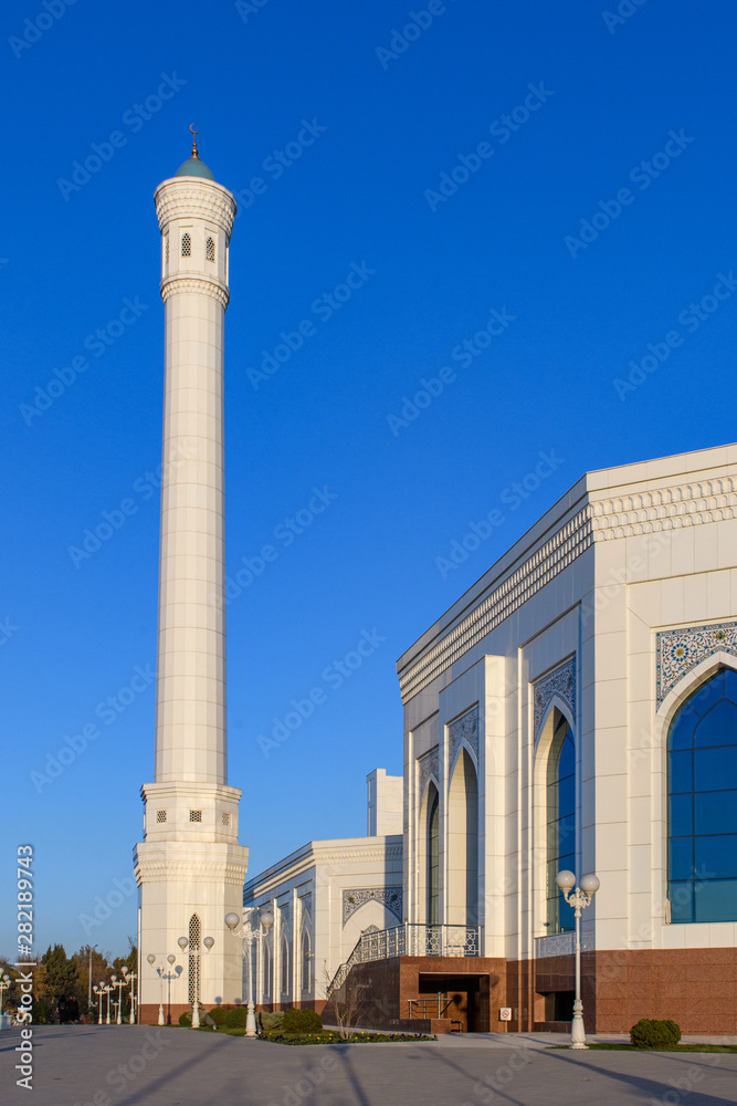 The beautiful domes and minarets of the Minor Mosque in the rays of the evening sun against a clear azure sky.