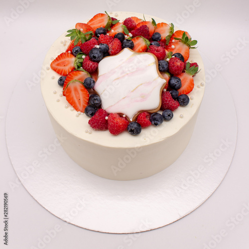 White cake decorated with berries.
