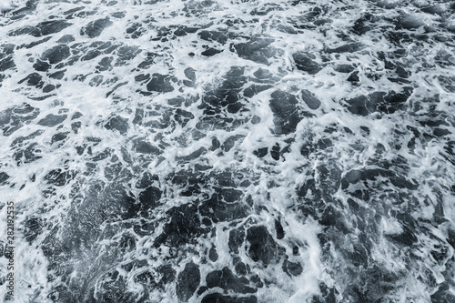 Organic background of dark blue aqua sea water surface splashing outside. Horizontal colour photography.