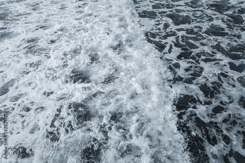 Top view of beautiful rough dark foamy blue sea surface. Horizontal color photography.