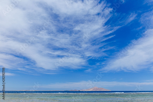 Beautiful seascape. Horizontal color photography of blue sky and Egyptian island seen far away in distance at horizon. 
