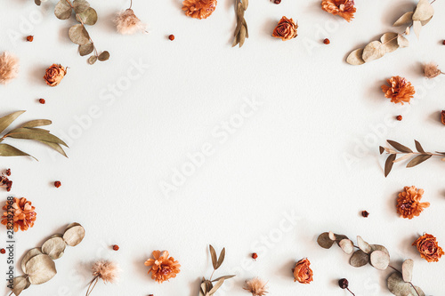 Autumn composition. Frame made of dried flowers, eucalyptus leaves, berries on gray background. Autumn, fall, thanksgiving day concept. Flat lay, top view, copy space