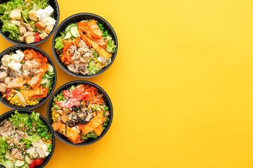 Many containers with delicious food on color background