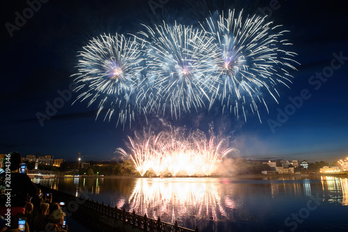 Beautiful pyrotechnic fireworks at night over the water. Celebration.