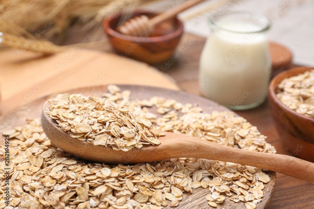 Spoon with oat flakes on plate, closeup Spoon with oat flakes on plate, closeup