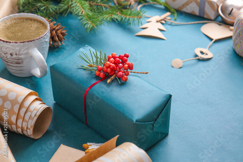 Beautiful Christmas gift box with cup of coffee on color background