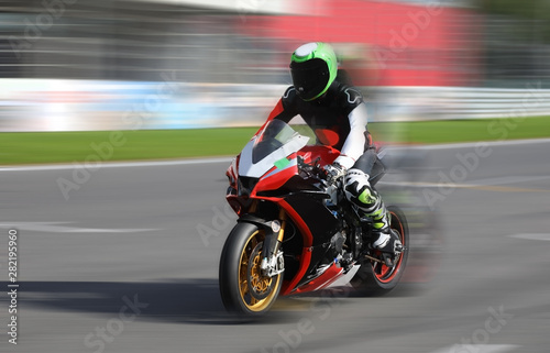 Motorcycle racer in helmet at high speed racing
