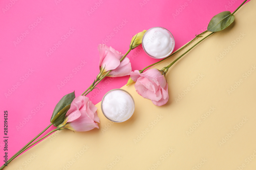 Body cream with flowers on color background