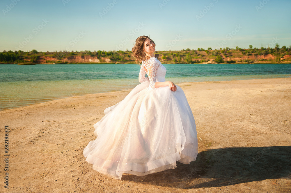Romantic wedding couple on the shore. The bride runs along the shore against the backdrop of a lake or sea close-up and copy space. Romantic wedding couple on the shore. The bride runs along the shore against the backdrop of a lake or sea close-up and copy space.