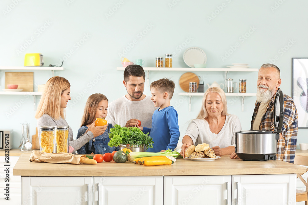 Happy family with modern multi cooker in kitchen Happy family with modern multi cooker in kitchen