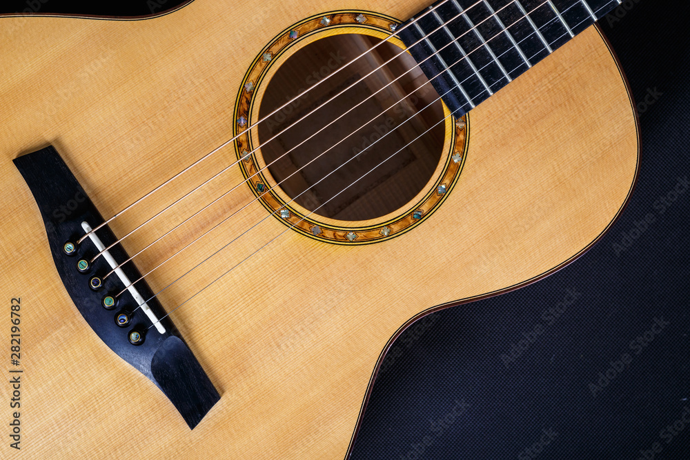 Obraz premium wood texture of lower deck of six strings acoustic guitar on black background. guitar shape