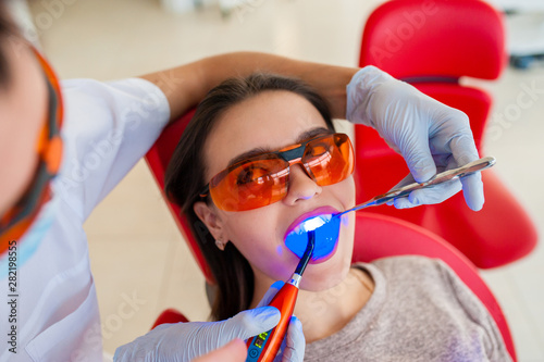 Treatment of light seal beautiful girl in dentistry.