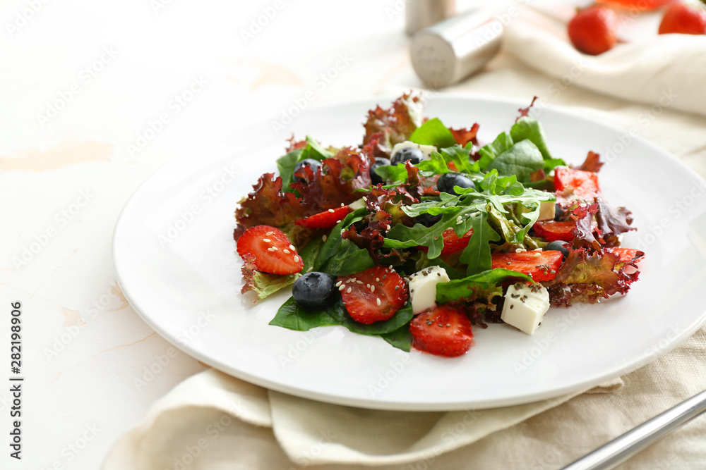 Plate with fresh tasty salad on table