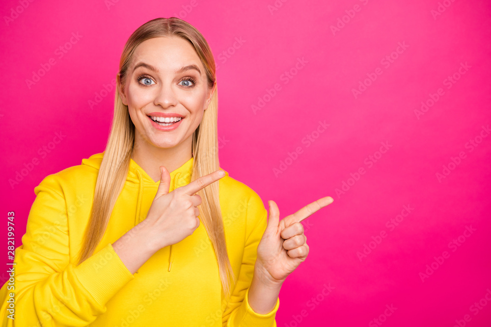 Pretty lady indicating empty space on banner with advert wear yellow hoodie pullover isolated pink background Pretty lady indicating empty space on banner with advert wear yellow hoodie pullover isolated pink background