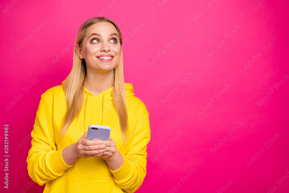Pretty lady holding telephone hands looking up empty space wear yellow hoodie isolated pink background Pretty lady holding telephone hands looking up empty space wear yellow hoodie isolated pink background