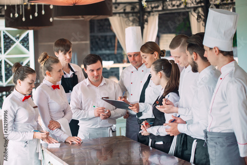 Restaurant manager and his staff in terrace. interacting to head chef in restaurant.
