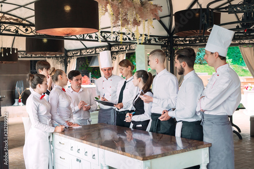 Restaurant manager and his staff in terrace. interacting to head chef in restaurant. photo