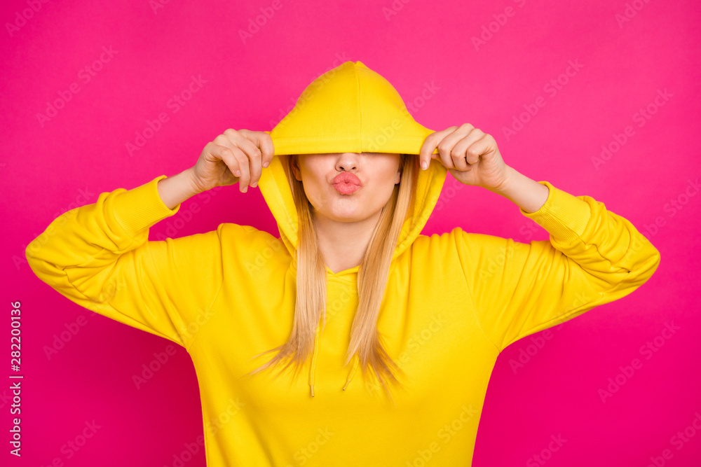 Photo of nice lady hiding eyes with hood sending air kiss wear yellow hoodie pullover isolated pink background Photo of nice lady hiding eyes with hood sending air kiss wear yellow hoodie pullover isolated pink background