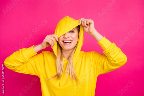 Closeup photo of nice lady hiding eyes with hood wear yellow hoodie pullover isolated pink background © deagreez