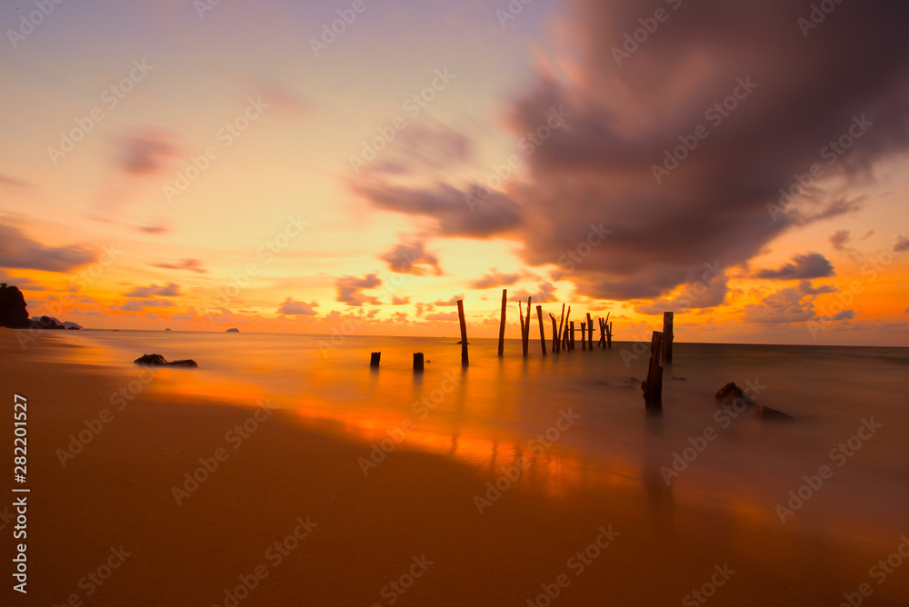 Beautiful sunset sunrise over the sea with old wooden bridge and rocks. Bright dramatic sky with clouds. Landscape under scenic colorful sky at sunset dawn sunrise, Sun over skyline, Horizon-Image