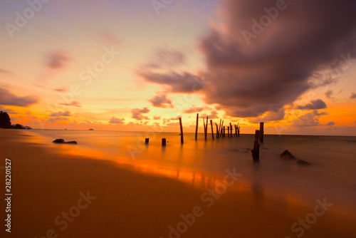 Beautiful sunset sunrise over the sea with old wooden bridge and rocks. Bright dramatic sky with clouds. Landscape under scenic colorful sky at sunset dawn sunrise  Sun over skyline  Horizon-Image