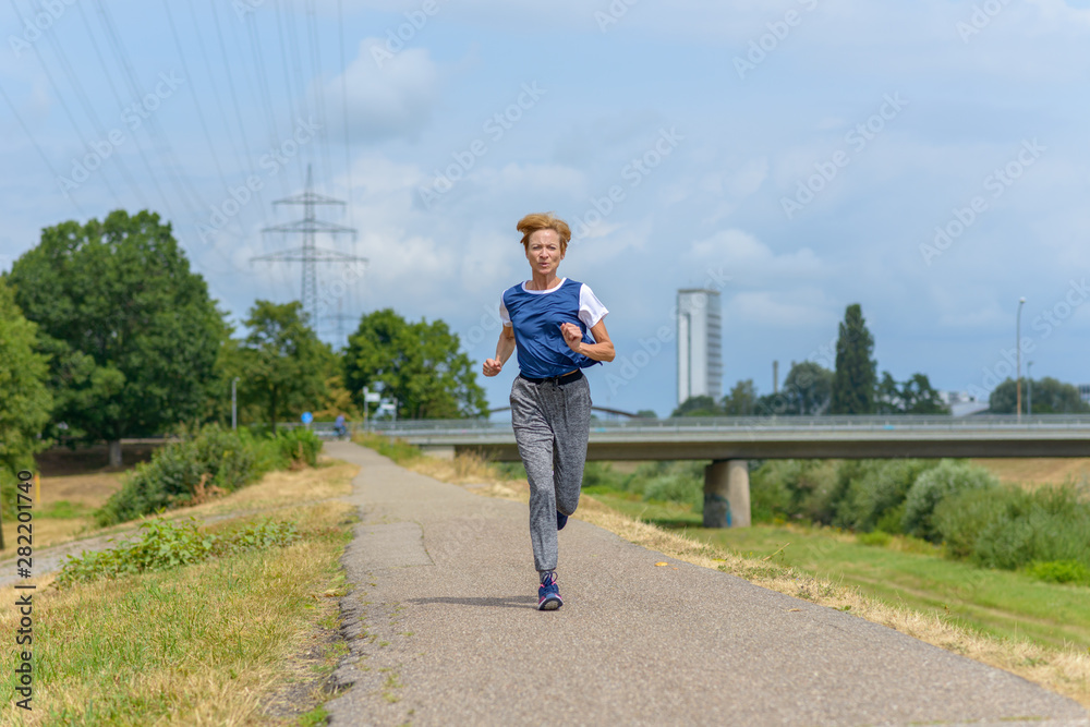 Fit healthy woman jogging in summer sunshine Fit healthy woman jogging in summer sunshine