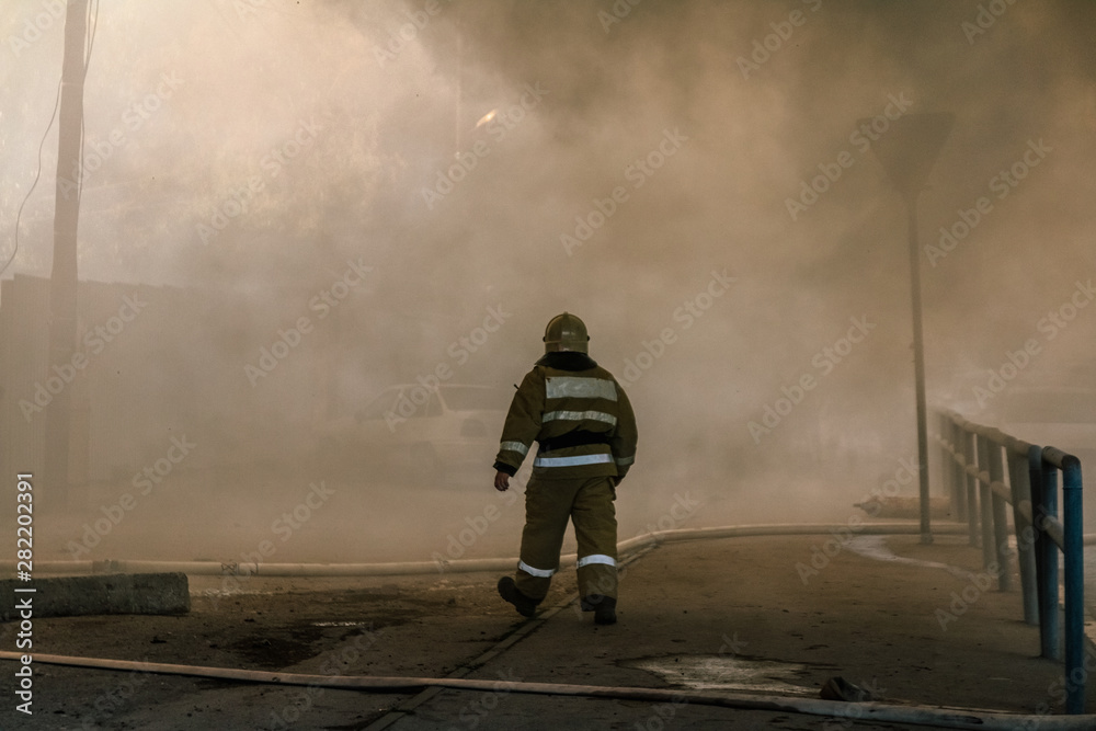 Firefighters extinguish a large house fire in smoke Firefighters extinguish a large house fire in smoke