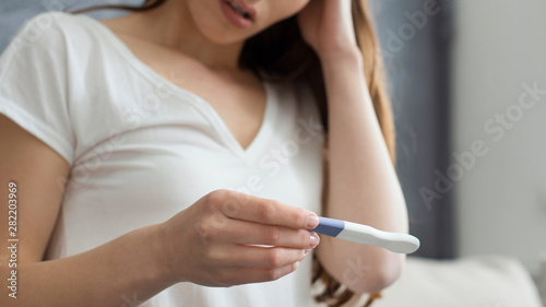 Cropped image of disappointed woman holding pregnancy test