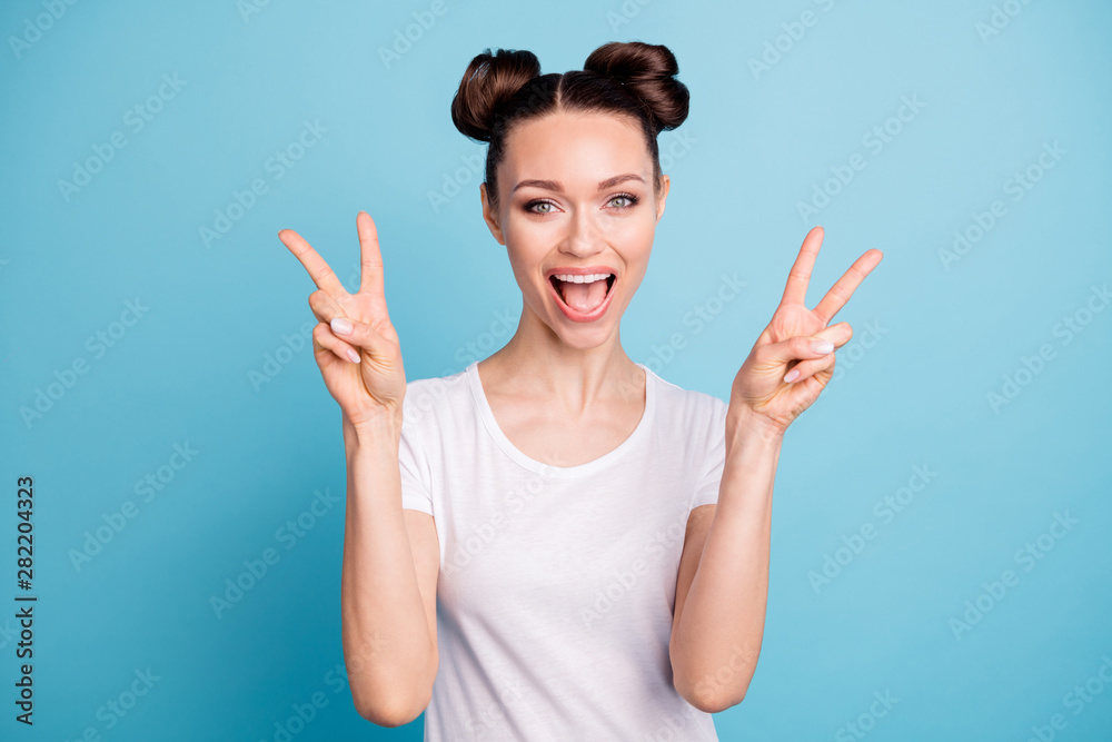 Nice lady hold hands showing v-sign symbol wear white casual t-shirt isolated blue bright background Nice lady hold hands showing v-sign symbol wear white casual t-shirt isolated blue bright background