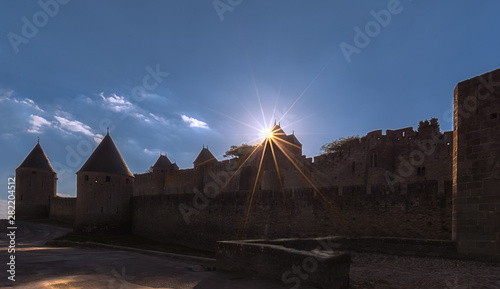 Beautiful sun star above a tower at the entrance of the the fortified city of Carcassonne in a clear blue sky day in France