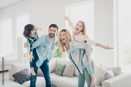 Profile photo of four family members having best free time pretend flight airplane indoors apartments