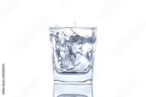 The ice cube splash into glass of water